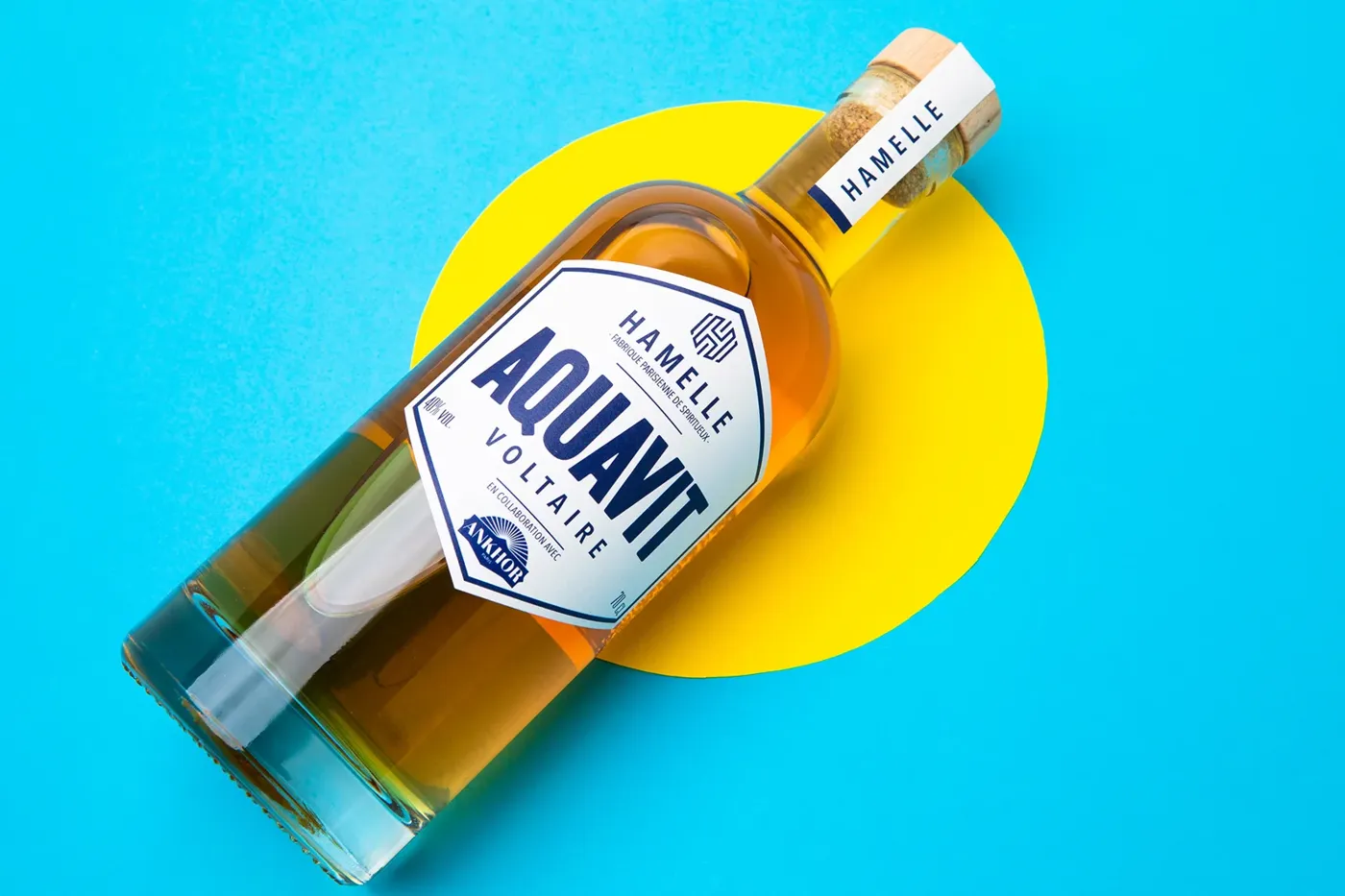 Bouteille d’aquavit en packshot sur fond bleu et jaune