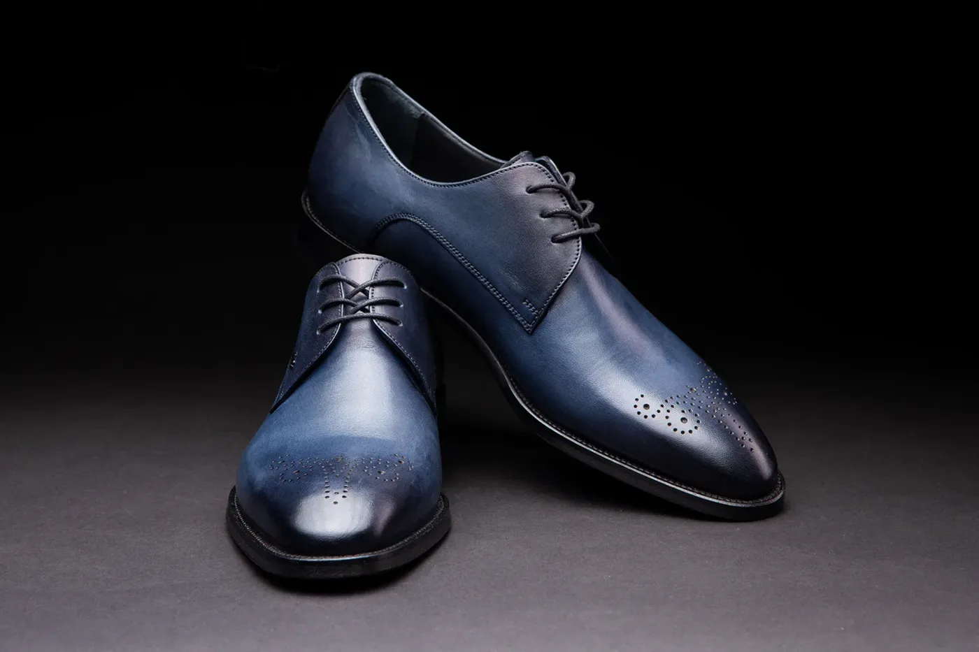 Souliers en cuir bleu photographiés sur fond sombre